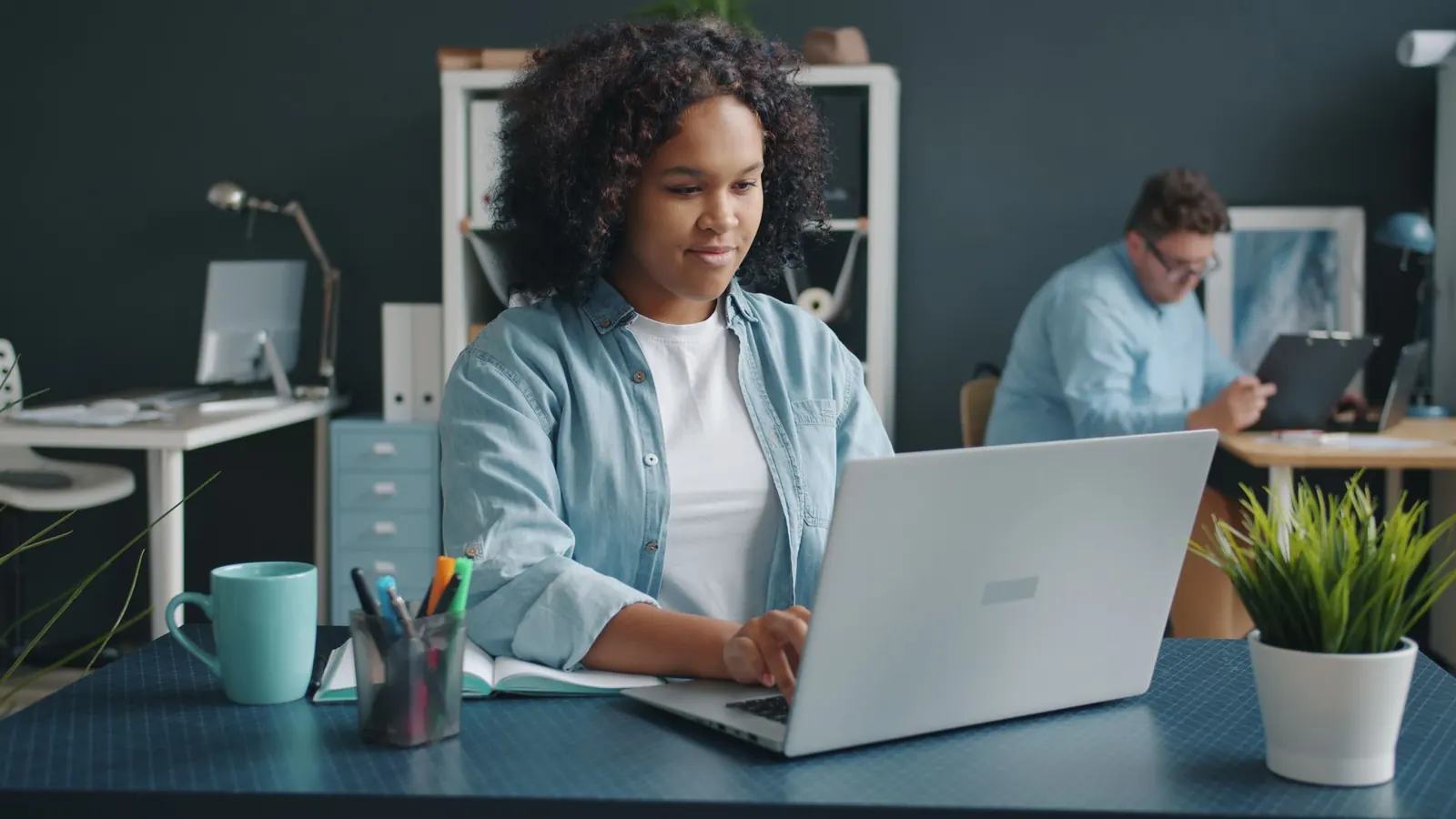 Profissional trabalha em um notebook em um escritório moderno.