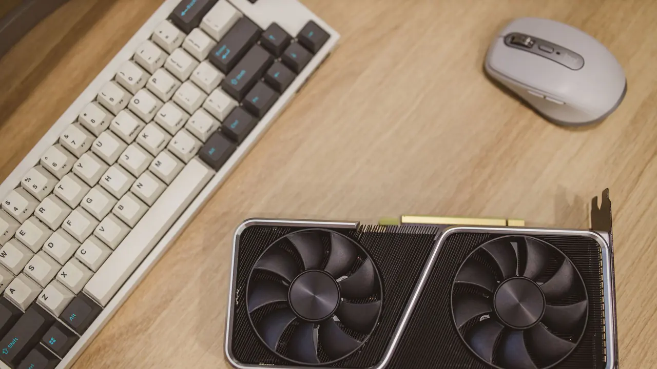 Placa de vídeo dedicada com duas ventoinhas ao lado de teclado e mouse.