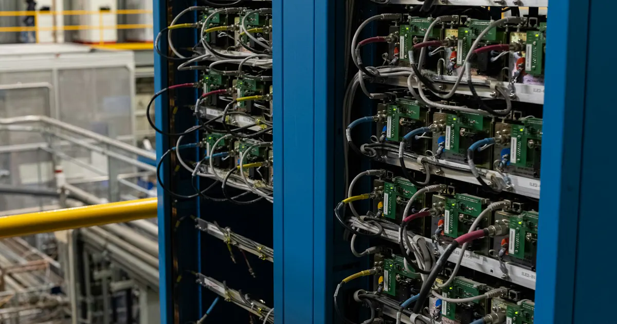 Racks de servidores com componentes eletrônicos e cabos organizados.