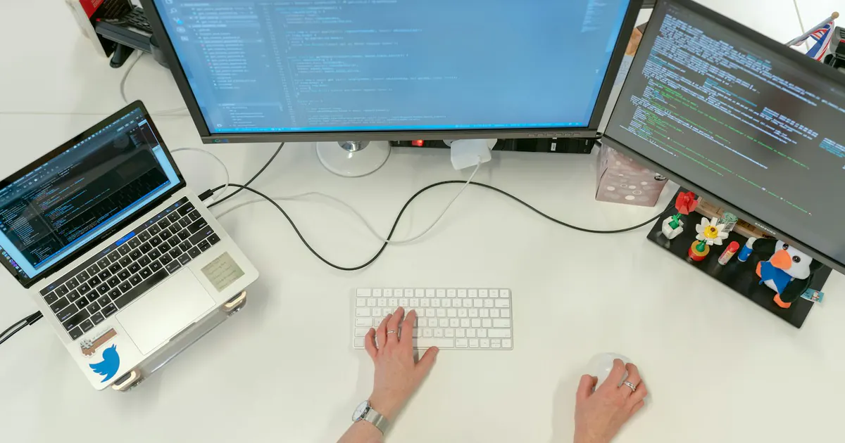 Engenheira trabalha em um notebook em sua estação de desenvolvimento.