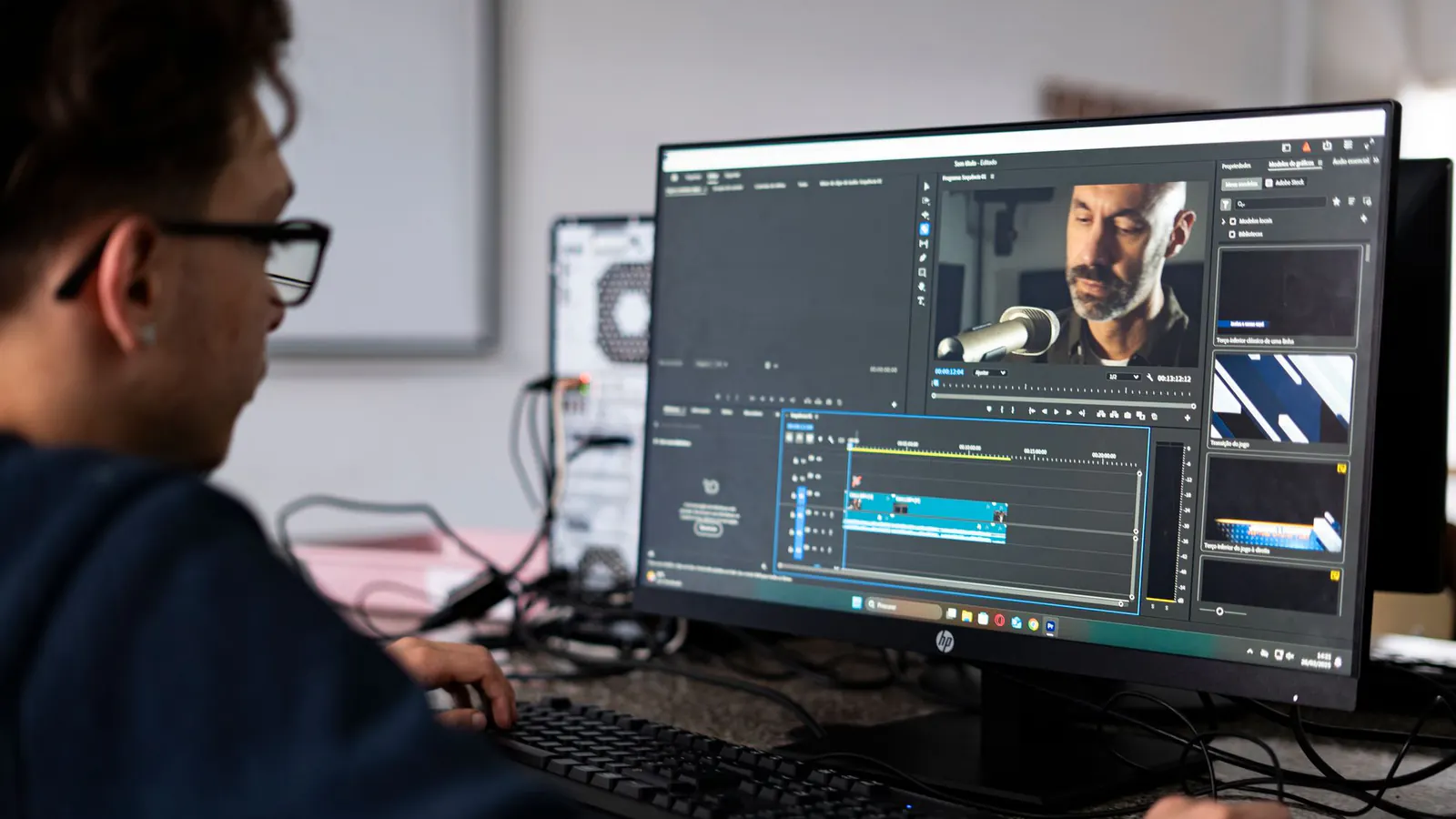 Editor trabalha em um projeto de vídeo em um computador de mesa.