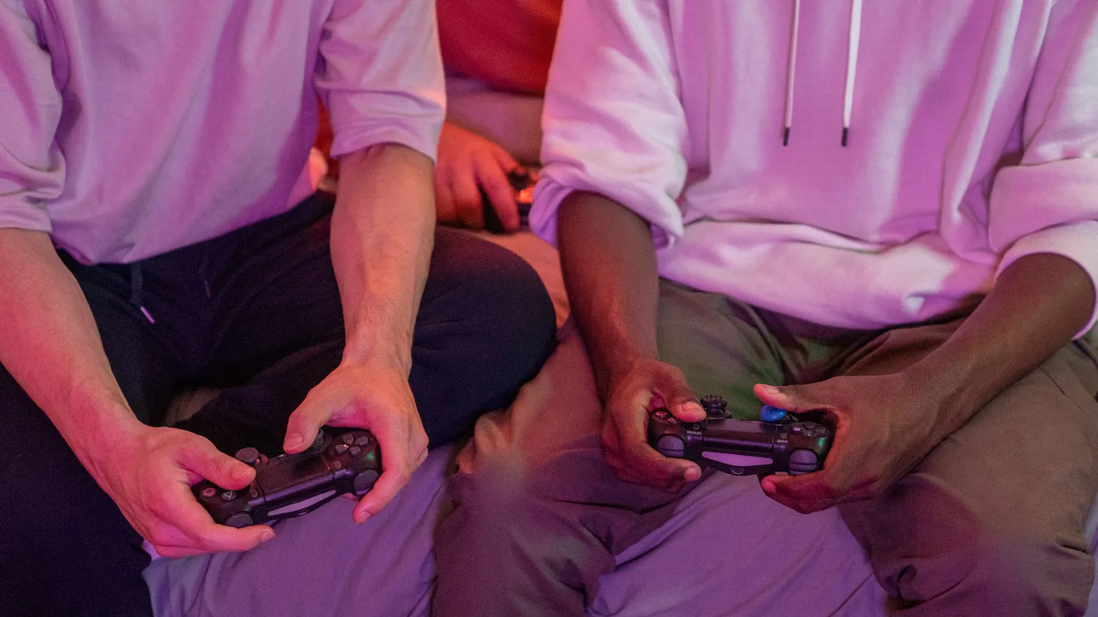 Duas pessoas jogam juntas usando controles em uma sala de estar.