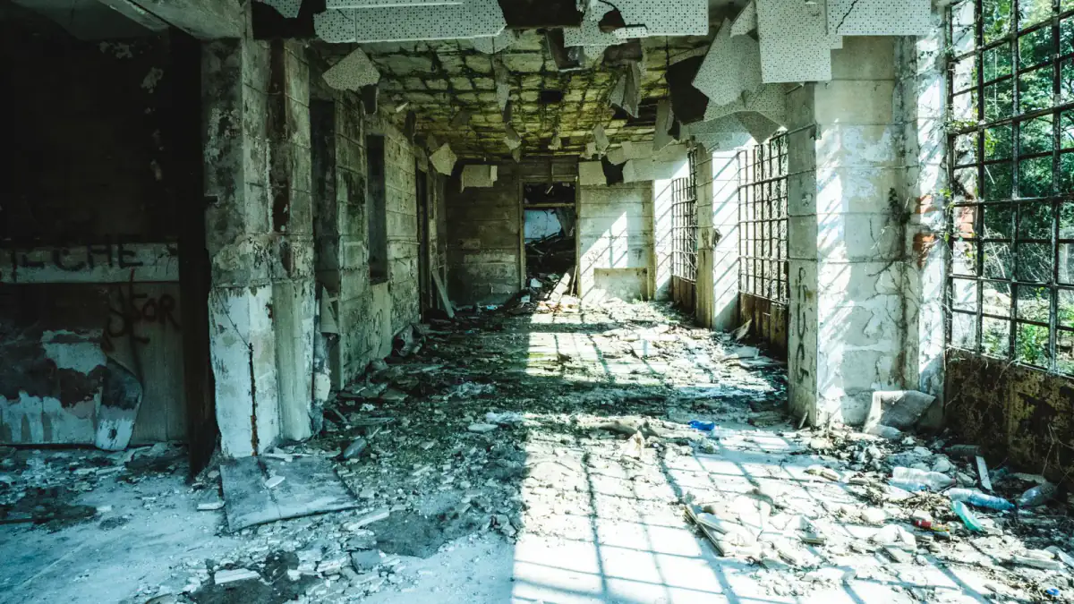 Interior de um edifício abandonado atravessado por luz natural.
